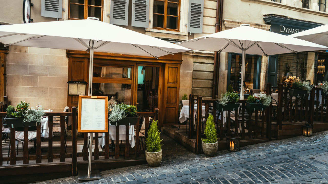 Terrasse du restaurant La Finestra avec parasols blancs et menu affiché