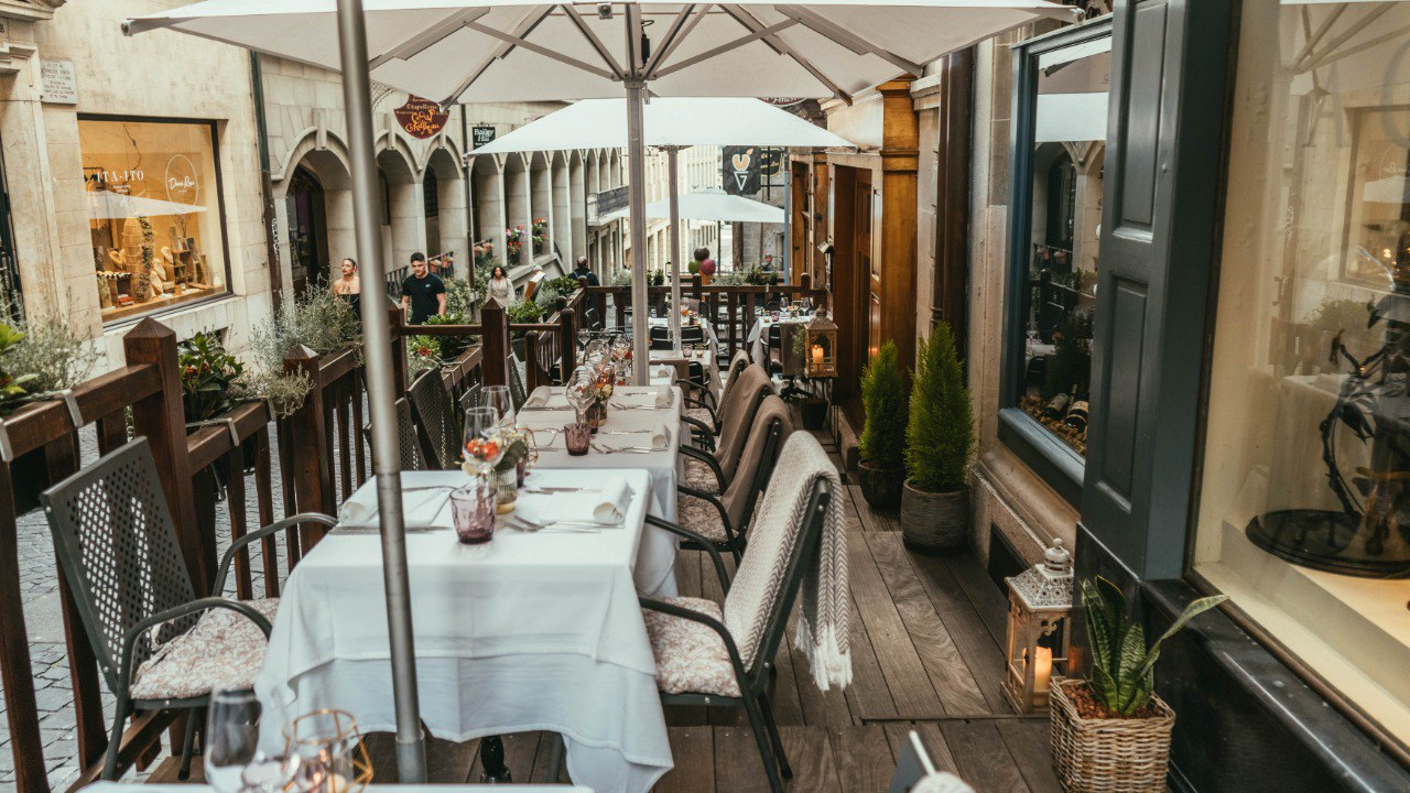Terrasse du restaurant La Finestra dans une rue gastronomique de Genève avec parasols et tables dressées